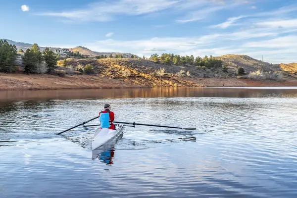 シニア男性は沿岸のローイングシェルを漕いでいます コロラド州北部の秋や冬の景色のホースペット貯水池 — ストック写真