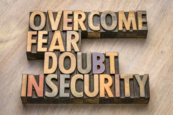 overcome fear, doubt, insecurity - inspirational words in vintage letterpress wood type, personal development concept