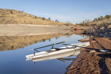 Lothe, CO, ABD - 30 Ocak 2024: Kıyı kürek kabuğu, Literace 1x Liteboat, kuzey Colorado 'daki Carter Gölü kıyısı .