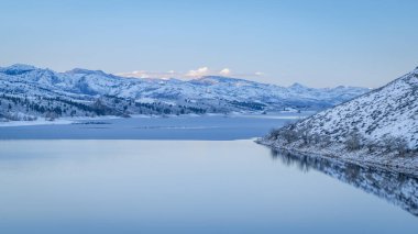 Kuzey Colorado 'nun eteklerindeki kısmen donmuş Horsetooth Reservoir üzerinde kış alacakaranlığı
