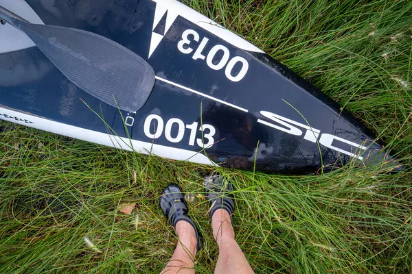 フォートコリンズ Usa 2019 Sic X14 Proのボウはパドラーの足で草の海岸にパドルでパドルボードを立ち上げました — ストック写真