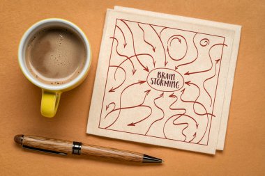 Düşünceleri, fikirleri, girdileri ve geri bildirimleri temsil eden oklarla beyin fırtınası konsepti, kahve ile peçetenin üzerine çizim