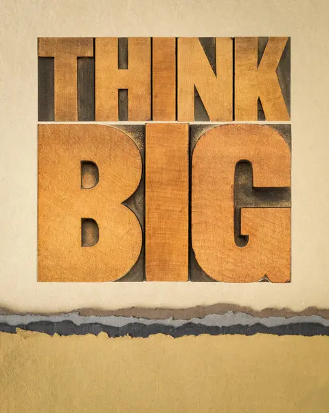 think big motivational phrase - text abstract in letterpress wood type on art paper, inspirational and personal development concept