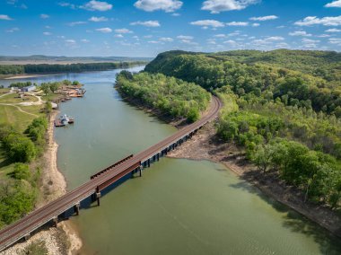 Gasconade Nehri, Missouri Nehri 'nin kesiştiği yerde demiryolu köprüsü ve eski bir tersaneyle bahar havası manzarası.