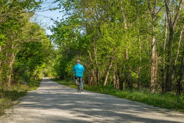 在密苏里州罗什波特附近的卡蒂小径上 骑自行车的男骑手正在骑一辆折叠式自行车 这是春天的风景 凯蒂小道 Katy Trail 是一条237英里的自行车道 由一条旧铁路改造而成 — 图库照片#