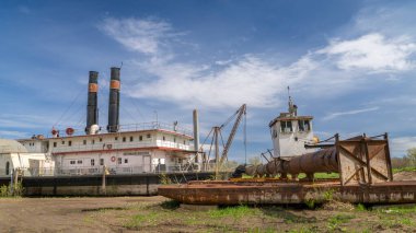 Brownville, NE, USA - April 19, 2024:  Historic river dredge, Captain Meriwether Lewis, in a dry dock on a shore of Missouri River. clipart