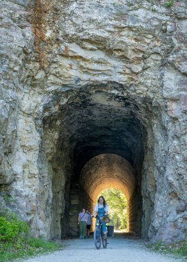 Rocheport, MO, USA - April 21, 2024: Biking and walking through MKT tunnel on Katy Trail. The Katy Trail is 237 mile bike trail stretching across most of the state of Missouri converted from an old railroad. clipart