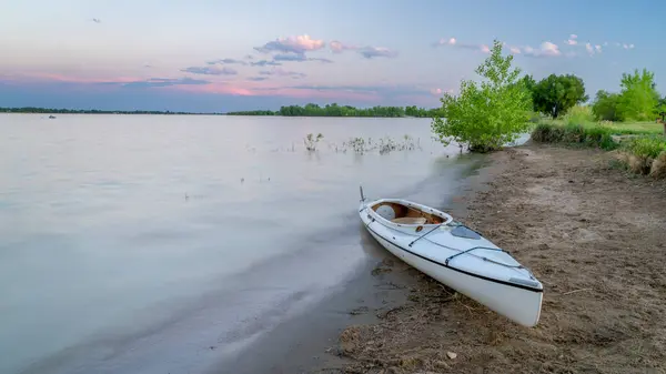 stock image expedition decked canoe on a lake shore at dusk after paddling, Boyd Lake in northern Colorado