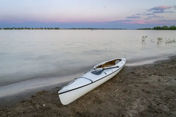 stock image expedition decked canoe on a lake shore at dusk after paddling, Boyd Lake in northern Colorado