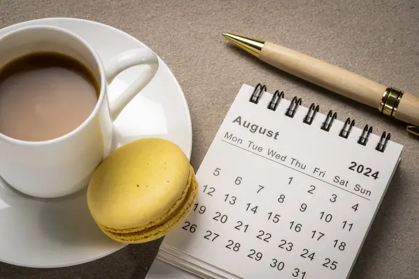 stock image August 2024 - small spiral desktop calendar with a stylish pen and a cup of coffee, time and business concept