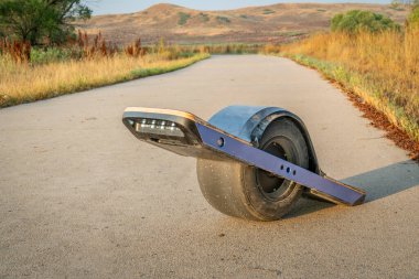 One-wheeled electric skateboard in the late summer morning on the Poudre River Trail in northern Colorado.