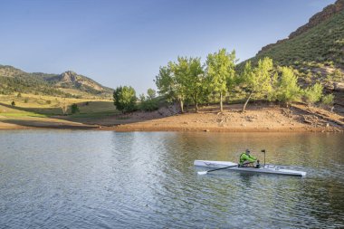 Kuzey Colorado 'da Horsetooth Reservoir' da kıyı kürek çeken yaşlı bir kürekçi.