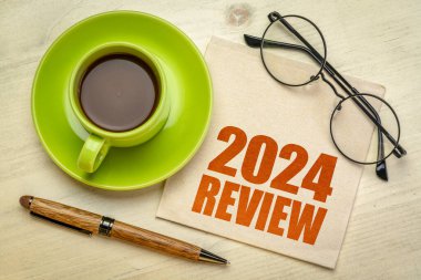 2024 yıllık inceleme metni bir fincan kahveyle birlikte bir peçetenin üzerinde, yıl sonu iş konsepti
