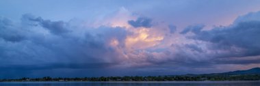 dramatic sunset sky and  clouds over Rocky Mountains and lake in northern Colorado clipart