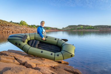 Son sınıf erkek kürekçi Colorado 'daki Horsetooth Barajı' nın kıyısında şişme bir yük kamyonu fırlatıyor.