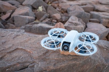Fort Collins, CO, ABD - 1 Ekim 2024: DJI Neo mini drone kumtaşı kayaları üzerinde, selfie çubuğu veya tripod 'a yaratıcı ve eğlenceli bir alternatif sunuyor..
