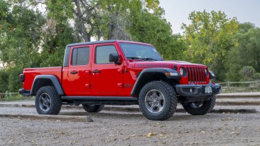 Fort Collins, CO, ABD - 2 Ekim 2024: Yeni bir Jeep Gladyatörü, Rubicon modeli bir patika başındaki otoparkta.