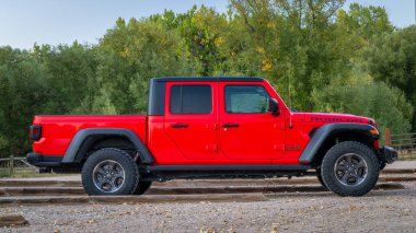 Fort Collins, CO, ABD - 2 Ekim 2024: Yeni bir Jeep Gladyatörü, Rubicon modeli bir patika başındaki otoparkta.