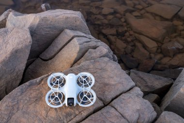 Fort Collins, CO, ABD - 1 Ekim 2024: DJI Neo mini drone kumtaşı kayaları üzerinde, selfie çubuğu veya tripod 'a yaratıcı ve eğlenceli bir alternatif sunuyor..