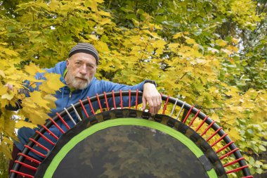 Spor ve ribaund için mini trambolini olan son sınıf öğrencisi, sonbahar manzarası.