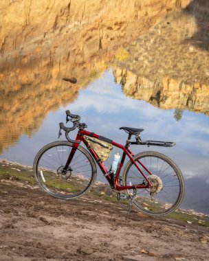 Fort Collins, CO, ABD - 2 Kasım 2024: Bir çakıl bisikleti, Trek Kontrol Noktası SL6, Colorado 'da Horsetooth Reservoir sahilinde kum taşı yansıması ile.