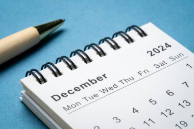 Aralık 2024 - Soyut kağıt manzarası, zaman ve iş konseptine karşı küçük spiral masaüstü takvimi