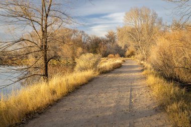 Fort Collins, Colorado 'daki doğal alanlardan birinde çakıl bisikleti ve yürüyüş parkurları, gün batımında sonbahar manzarası