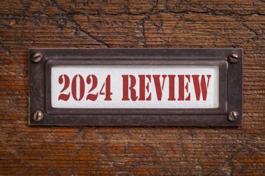 2024 gözden geçirme - grunge ahşap dosya dolabında bir etiket. Geçen yıl değerlendirmesi, özet ve gözden geçirme kavramı.
