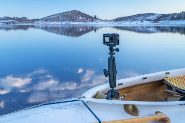 Fort Collins, CO, USA - January 8, 2025: DJI Action 5 camera mounted with RAM mount onan decked expedition canoe, dusk winter scenery on Horsetooth Reservoir  in Colorado.