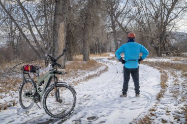 Kuzey Colorado 'da Poudre River Trail' de gezici elektrikli bisikleti olan erkek bisikletçi, kış manzarası