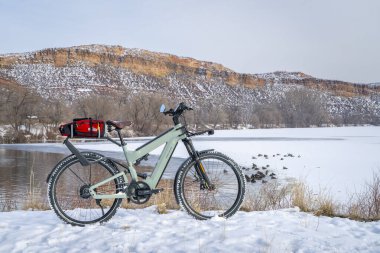 Bellvue, CO, ABD - 19 Şubat 2025: Superdelite, Riese Muller tarafından Colorado eteklerinde kazlarla donmuş gölün kıyısında gelişmiş bir tur e-bisikleti.