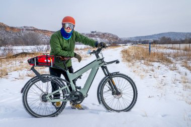 Colorado eteklerinde kışın bisiklet turu yapan yaşlı bir bisikletçi.
