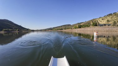 Sabahları Colorado 'daki Horsetooth rezervuarının sakin suyunda kürek çekmek - POV kürek perspektifi