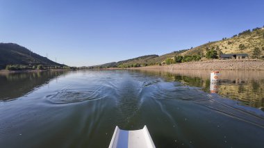Sabahları Colorado 'daki Horsetooth rezervuarının sakin suyunda kürek çekmek - POV kürek perspektifi