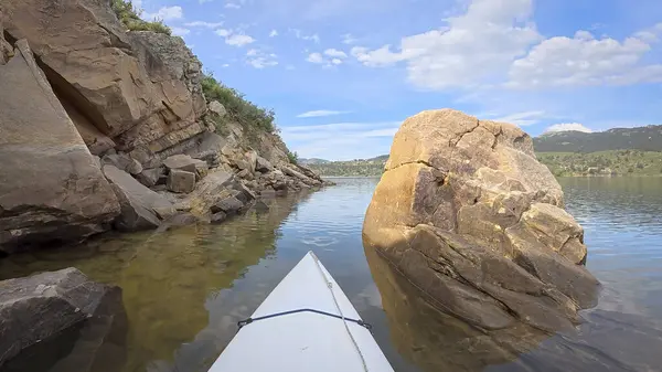 Fort Collins, Colorado yakınlarındaki Horsetooth Barajı 'nın kayalık bir kıyısı boyunca kumtaşı bir kanyonda kano ya da kano gezisi.