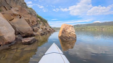 Fort Collins, Colorado yakınlarındaki Horsetooth Barajı 'nın kayalık bir kıyısı boyunca kumtaşı bir kanyonda kano ya da kano gezisi.