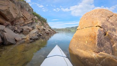 Fort Collins, Colorado yakınlarındaki Horsetooth Barajı 'nın kayalık bir kıyısı boyunca kumtaşı bir kanyonda kano ya da kano gezisi.