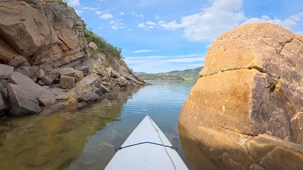 Fort Collins, Colorado yakınlarındaki Horsetooth Barajı 'nın kayalık bir kıyısı boyunca kumtaşı bir kanyonda kano ya da kano gezisi.