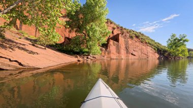 Fort Collins, Colorado yakınlarındaki Horsetooth Barajı 'nın kayalık bir kıyısı boyunca kumtaşı bir kanyonda kano ya da kano gezisi.