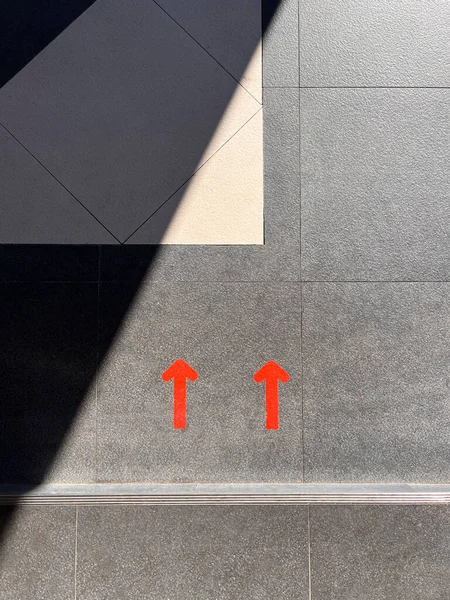 two red arrows on a floor of contemporary architecture