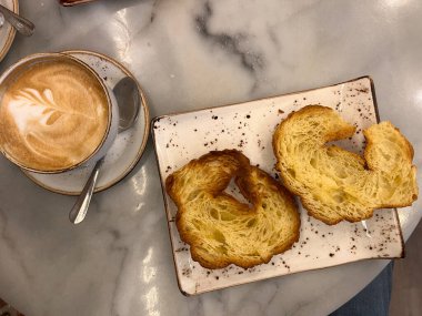 Geleneksel Madrid kahvaltısı sütlü kahve ve ızgara kruvasanla.