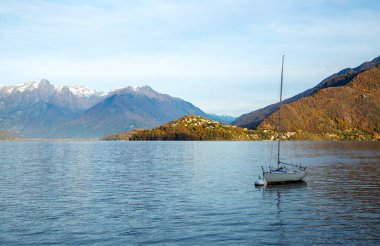 Gölde yalnız bir tekne, gün batımı ışığı, yatay manzara.