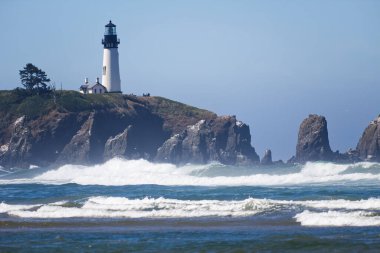 Uçurumdaki Deniz feneri Mavi Oregon sahiline karşı dalgalar kırıyor.