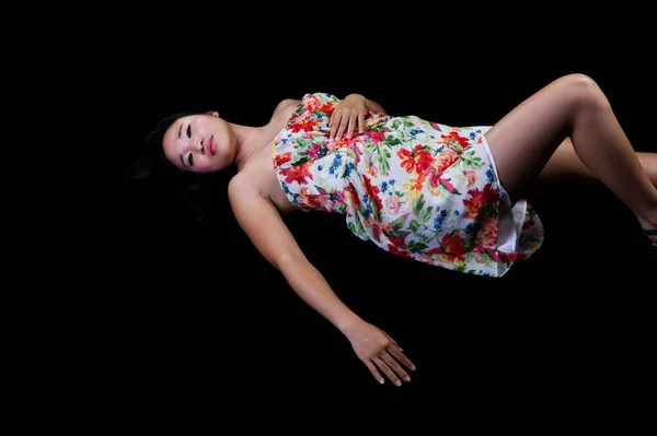 Ελκυστική Λεπτή Ιαπωνική Αμερικανίδα Γυναίκα Ξαπλωμένη Σκούρο Φόντο Λουλουδάτο Φόρεμα — Φωτογραφία Αρχείου