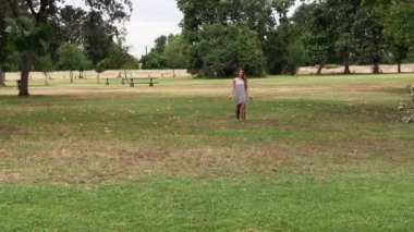 Caucasian Teen Girl Gray Dress Running Towards Camera Over Green Grass In Sandals