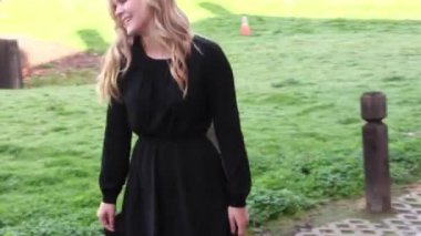 Young Blond Woman In Black Dress Spinning Around Outdoors Handheld Shot