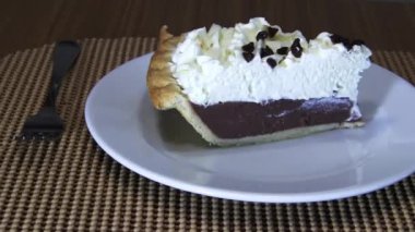 Camera Moving Left To Right Past Chocolate Cream Pie On White Plate