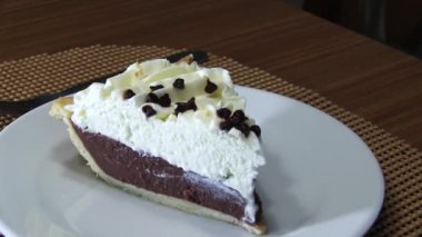 Camera Moving Right To Left Past Chocolate Cream Pie On White Plate