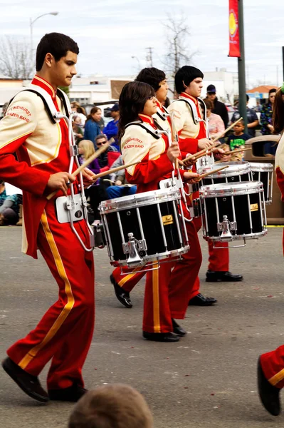 赤と黄色のユニフォームを着た小さな町のパレードで行進バンドの十代のドラマー — ストック写真