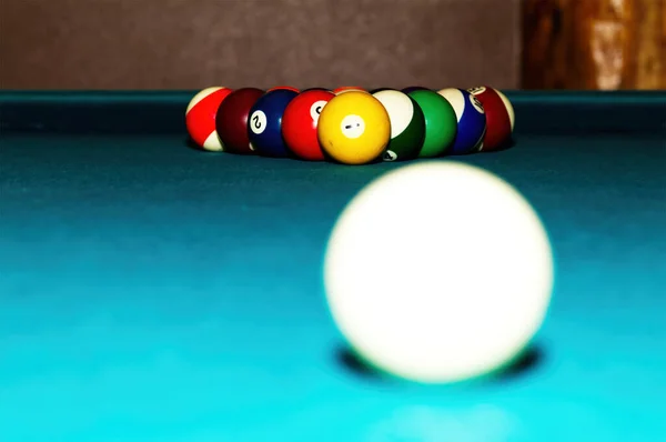 Pool Table With Balls Racked Up For Break And Bright Cue Ball In The Foreground